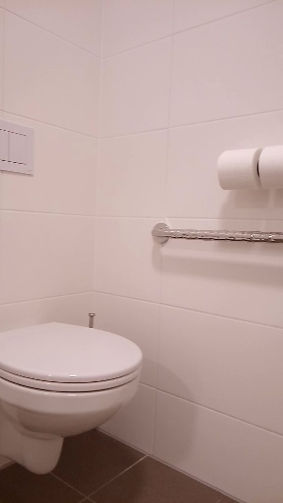 Barrierefreies Hotelzimmer mit Haltegriff neben der Toilette